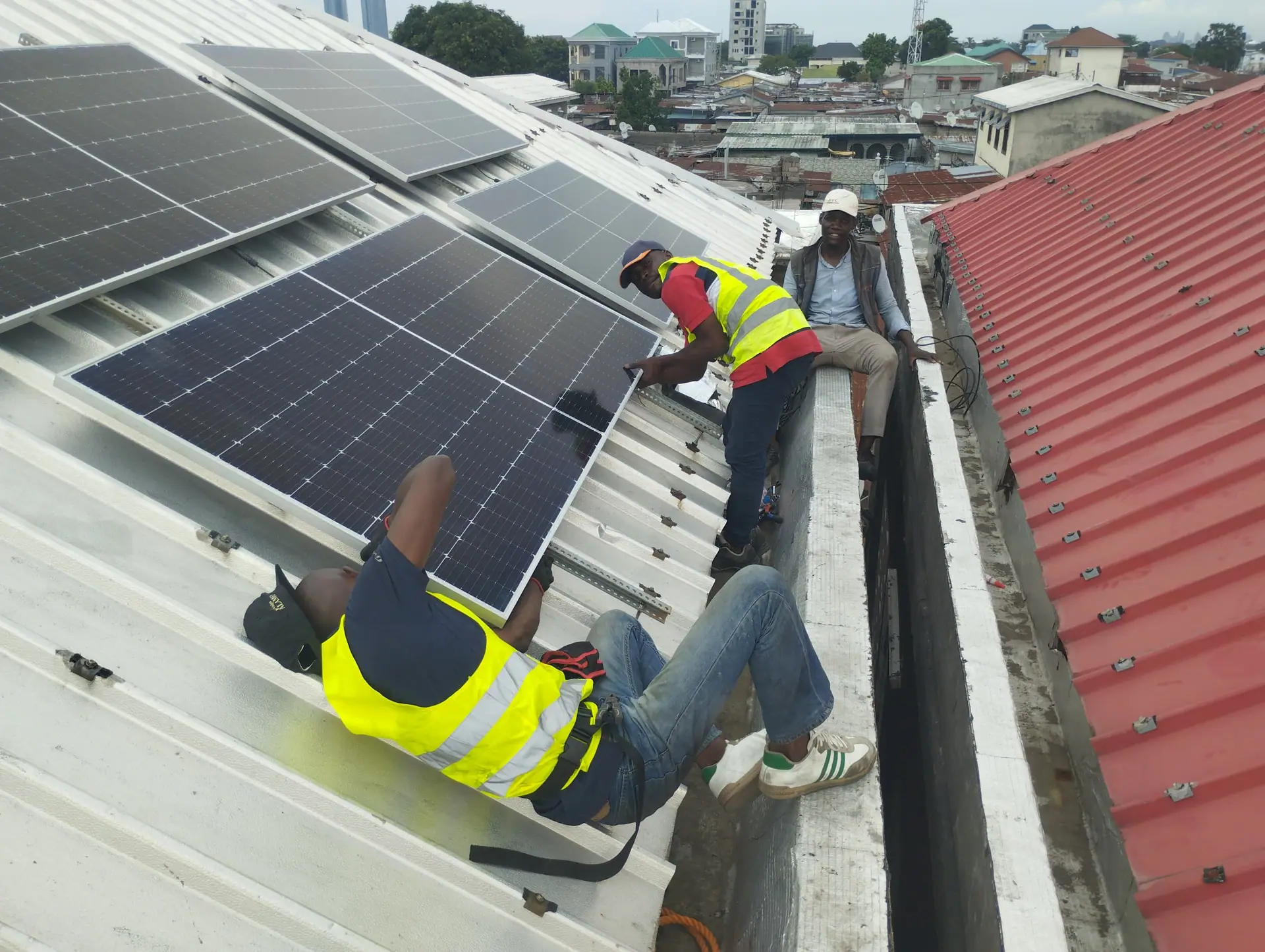 L'équipe BOMOYE installant une rangée de panneaux solaires