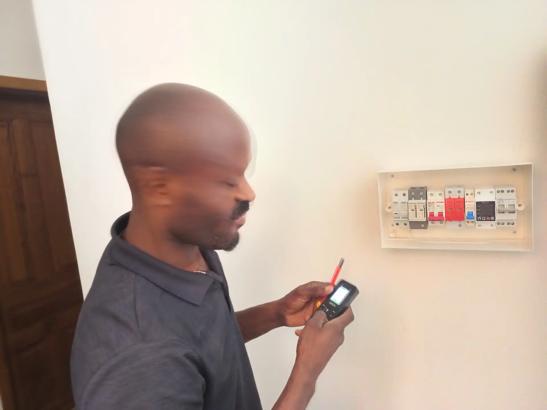 Technicien BOMOYE mesurant la tension de l'installation lors de la mise en service